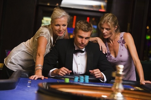 Джентельмен в компании двух элегантных дам совершает ставку на рулетке