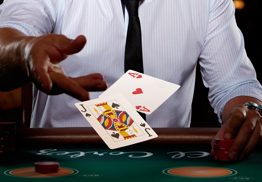 Руки игрока, бросающего пиковый валет и червовый туз