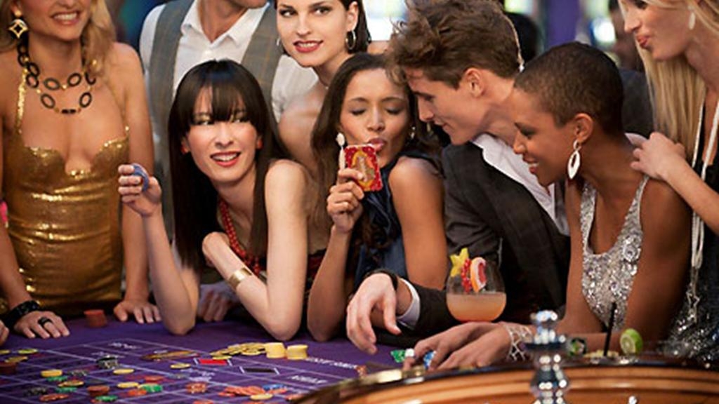 Молодые красиво одетые девушки веселятся за игрой в рулетку