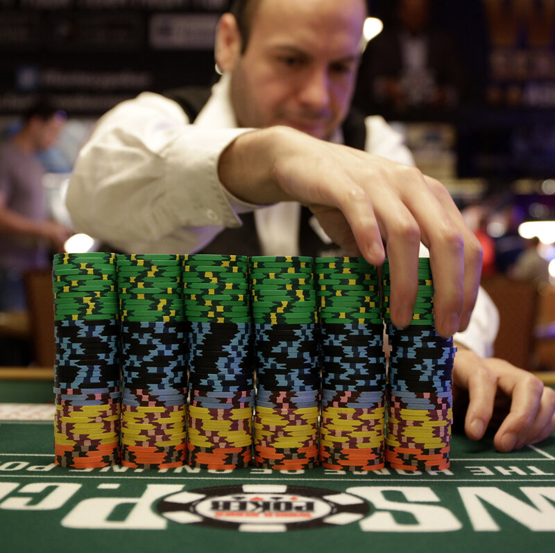 Крупье за игровым столом в покерном турнире